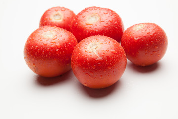 Tomate, rojo, sano con gotas de agua sobre fondo blanco
