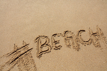 hashtag written by hand in the sand