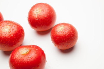 Tomate, rojo, sano con gotas de agua sobre fondo blanco