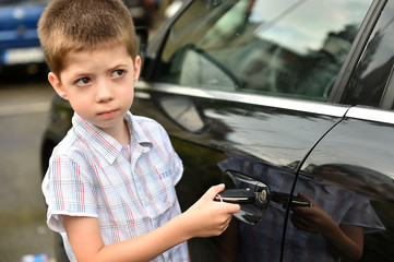 child boy open the car door with car key