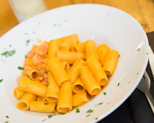 Rigatoni pasta with bacon, tomato and cream