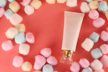 Facial cleansing foam on pink background and cotton wool