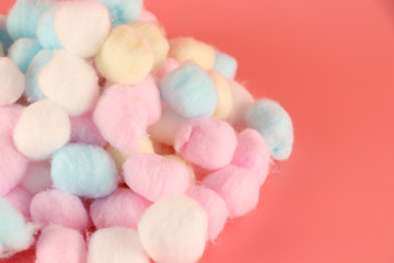 Multicolored cotton wool on a pink background