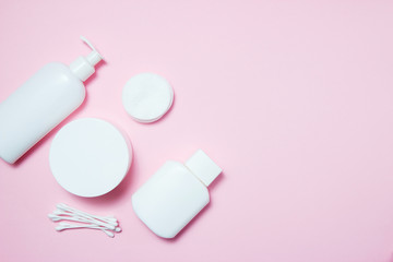 White jars of cosmetics on a pink background. Bath accessories. Face and body care concept