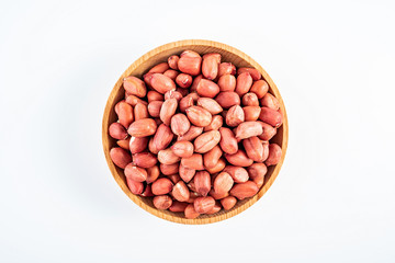 Dried red peanuts in a saucer on a white background