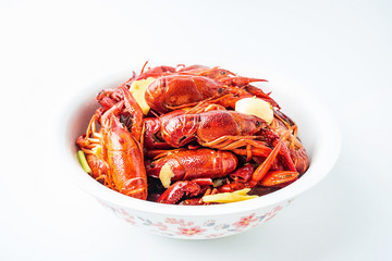 A large bowl of bright red delicious braised crayfish on a white background