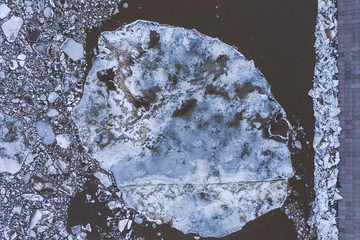 Aierial view from the top down on ice floes floating on the river.