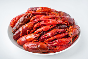 Delicious boiled crayfish on a saucer on a white background