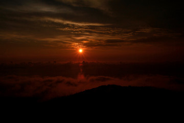 Beautiful structure of clouds on sky, mountain landscape with dense fog at sunset on horizon of beauty natural environment. Panorama of amazing sunrise view show sun rays through clouds over mountain.