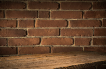 Old wooden table with brick background dark