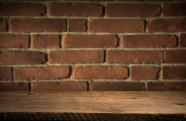 Old wooden table with brick background dark