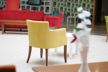 Red and yellow chairs, table in modern interior. Elelenta interior.