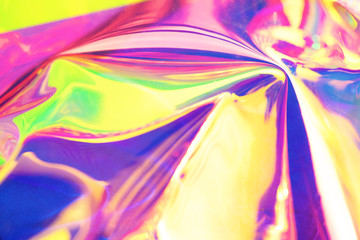 Fototapeta premium Holographic iridescent surface. Copy space. Bright colorful hologram background. Wrinkled abstract texture with multiple colors. Neon surface.