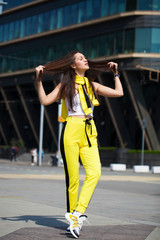 Portrait of a young beautiful brunette woman in yellow tracksuit