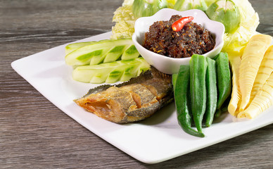 Fried chili paste, eaten with vegetables and fried fish, (thai language  nam prik pao) in white dish on wooden table thai food