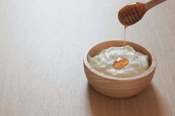 fresh greek yogurt topped with honey  on wooden table