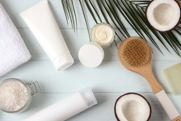 Coconut, tropical leaf and care products on a colored background top view. Cosmetics with coconut extract for hair, body, face. Skin care, skin hydration. flatlay