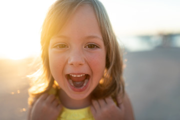 Little girl bursting out in laugher, portrait shot.