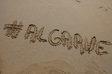 hashtag written by hand in the sand