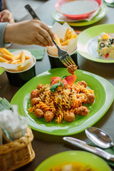 Kid hands and meatball pasta.