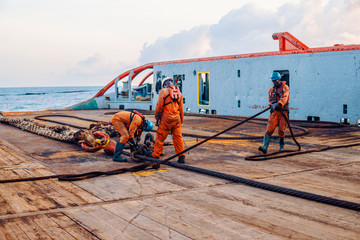 Anchor-handling Tug Supply AHTS vessel crew preparing vessel for static tow tanker lifting. Ocean...