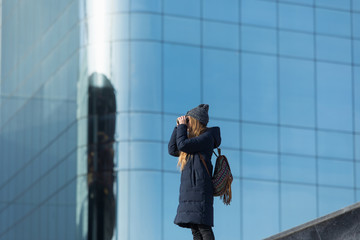 woman traveller looking at the binocular in front of the downtown