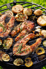 Grilled fish, grilled salmon steak with the addition of rosemary, aromatic spices and vegetables on...