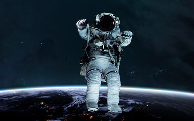 Astronaut at the Earth planet orbit. Awesome science fiction render. Elements of this image furnished by NASA
