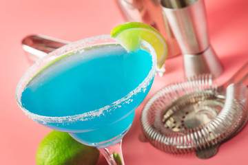 Blue margarita exotic alcoholic cocktail with tequila, liqueur, lime juice, salt and ice, summer blue background, place for text