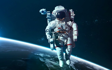 Fototapeta premium Astronaut at Earth orbit. Science fiction wallpaper. Elements of this image furnished by NASA