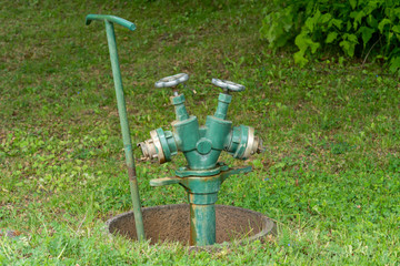 freistehender professioneller Wasserkran mit Anschluss für 2 Schläuche zur Bewässerung in Park...