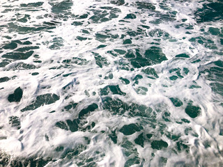 Restless movement of foam waves. Background of water in the sea.