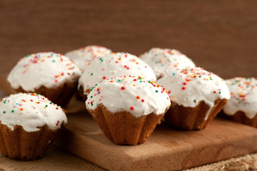 Easter cupcakes on wooden background. Close-up. Many easter cupcakes on the kitchen table. Dessert in the form of muffins. Food for Easter.