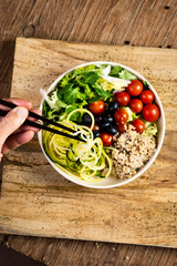 young man eating a buddha bowl salad