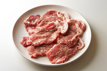 Fresh raw seasoned pork on plate 