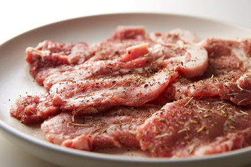 Fresh raw seasoned pork on plate 