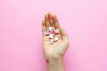 Small heart in hand woman on pink background.love.