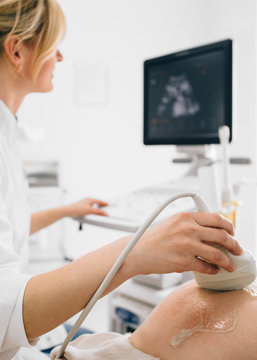 female doctor doing sonogram with pregnant woman at clinic. pregnant patient ultrasound exam