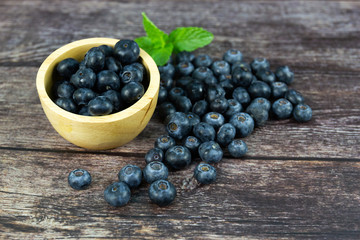 Fresh blueberries in a wooden bowl on wood table