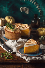 Pumpkin pie with meringue on a wooden table. Piece of cake. 