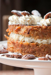 cropped shot of a freshly baked Carrot Cake with whipped cream and walnuts on a cake stand
