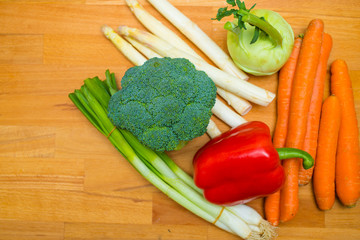 Carrots, Broccoli, Spring Onions, Kohlrabi and Asparagus on Wooden Background