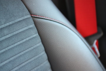 Leather and suede seat with red seat belt - obrazy, fototapety, plakaty
