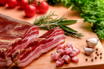 Bacon, spices and vegetables on wooden table