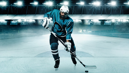 Fototapeta na wymiar Ice Hockey player athlete in the helmet and gloves on stadium with stick. Action shot. Sport concept.