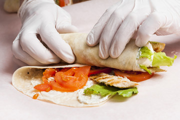 Hands preparing burrito