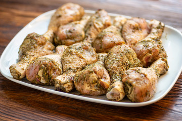 Chicken drumsticks  on white dish, wooden background