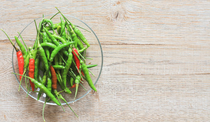 Guinea pepper, thai pepper in glass plate on wooden background.