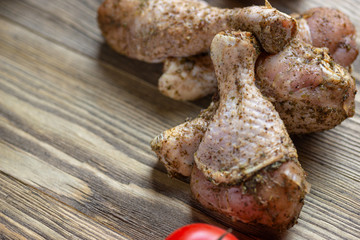Chicken leg with herbs on wooden table
