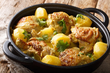 Popular spicy chicken coconut curry with potatoes close-up in a pan. horizontal